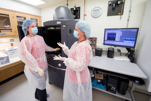 Two women in PPE talkikng