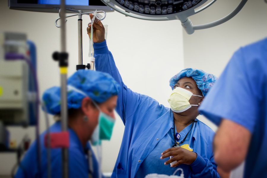 Medical staff prep operating room for surgery