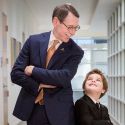 Dr. Downing standing back to back with male child patient