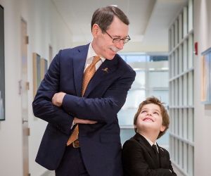 Dr. Downing standing back to back with male child patient