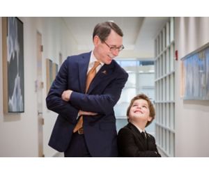 Dr. Downing standing back to back with male child patient