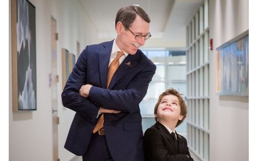 Dr. Downing standing back to back with male child patient