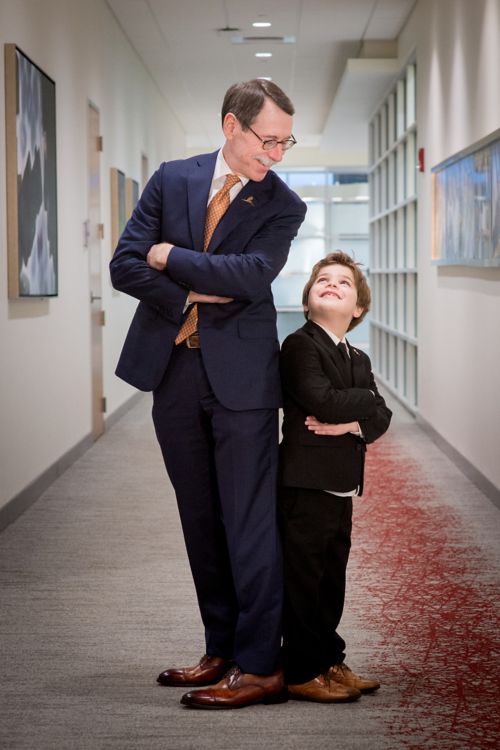 Dr. Downing stands back to back with a male child patient