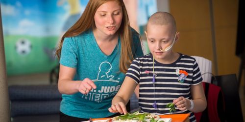 Zoe Oliver puts the finishing touches on her “dream pizza” with Sarah Schwartzberg,