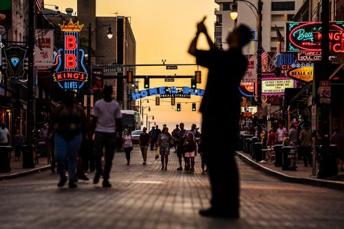 image of man taking cell phone picture on beale stsreet