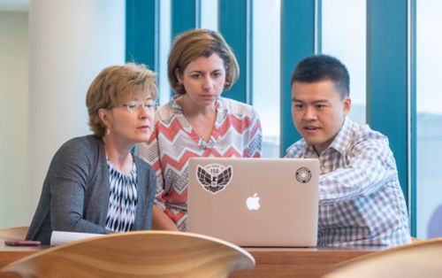 Three people looking at computer screen