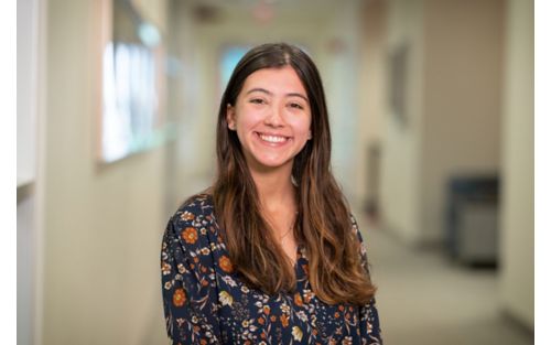 Woman in hallway smiling at camera