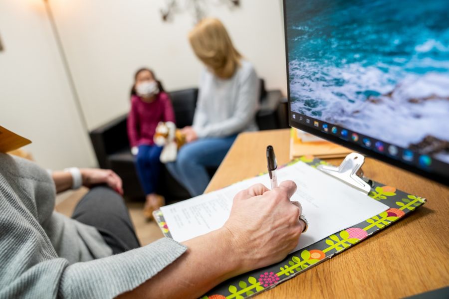 Mother and daughter in background of person filling out form