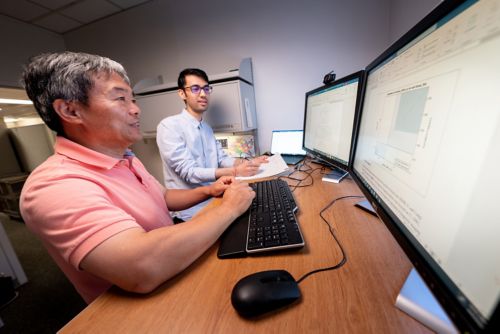 Two men looking at a computer screen.