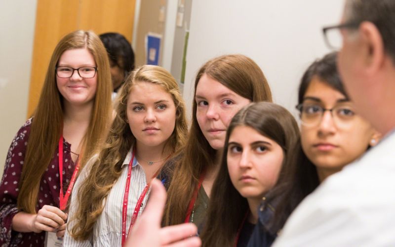 Photo of students listening to adult