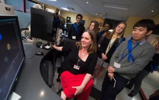 Photo of Jennifer Peters, PhD,  explaining microscope scans to students