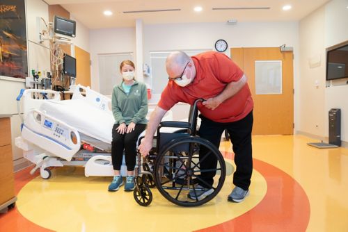 Get the wheelchair ready before you use the sliding board to move your child by removing the arm and leg rests.