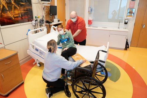  Place the sliding board under your child’s hips and thigh after lifting their leg.