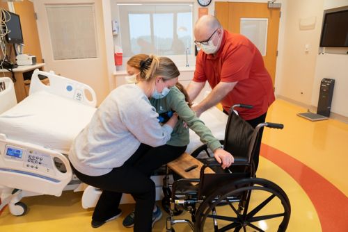 Have your helper use the gait belt to slide your child across the board in a sitting position. Have your child pull the armrest to help get themself into the wheelchair.