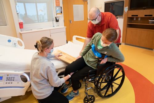 Have your child lean on the armrest while you pull the sliding board from under them.