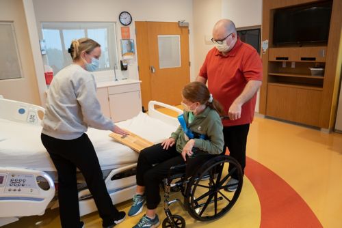 Have your child lean on the armrest while you slide the board under their hip and thigh.