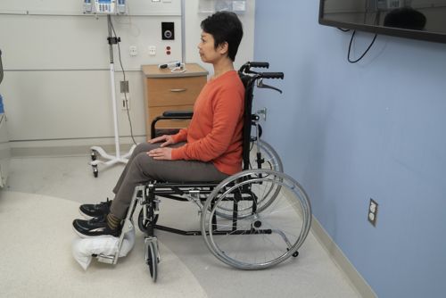 Woman sitting upright in a wheelchair.