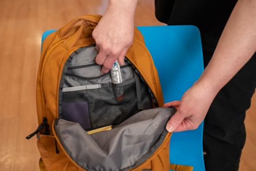 Person packing an epinephrine pen in their bag