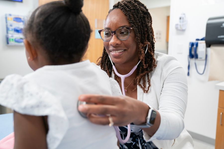 A female doctor checking a child's breathing