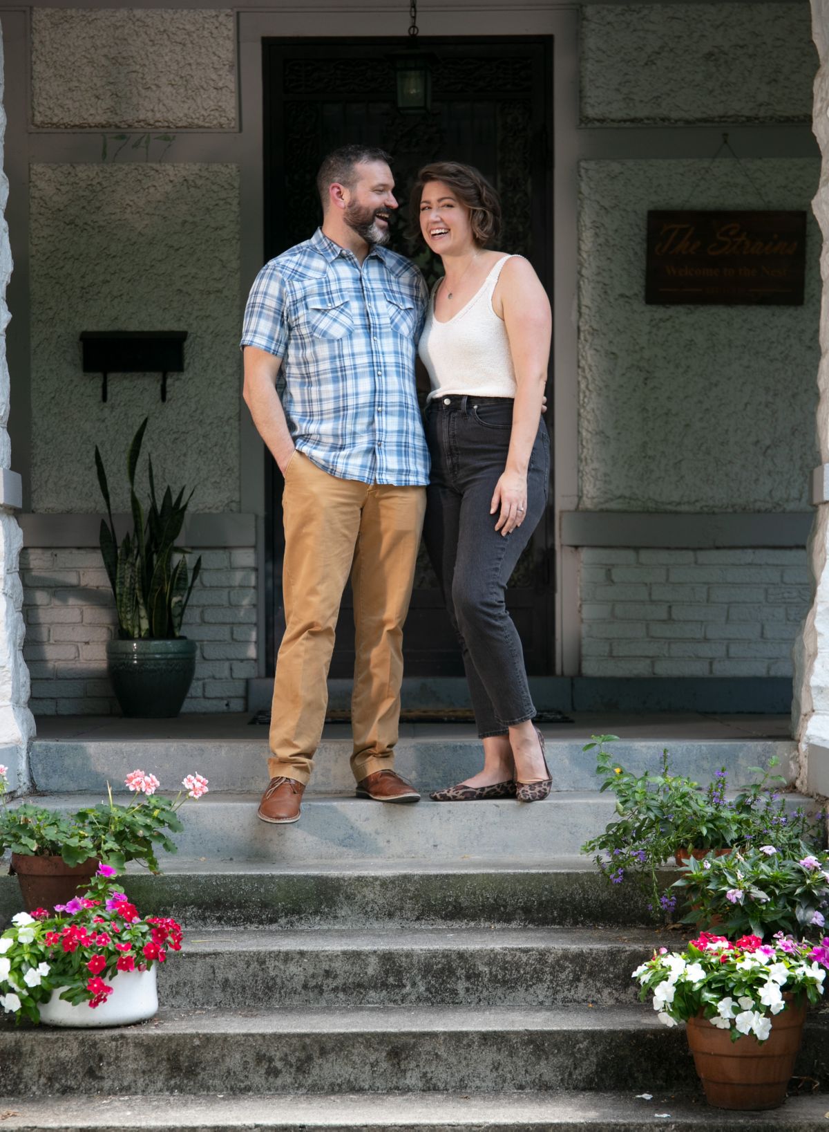 Sarah Strain and her husband stand on their front porch