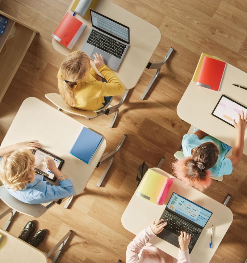 Photo of overhead view of children at desks in classroom