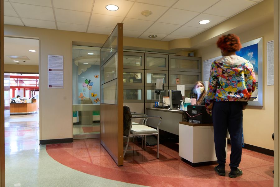 Person talking to receptionist who is sitting at desk