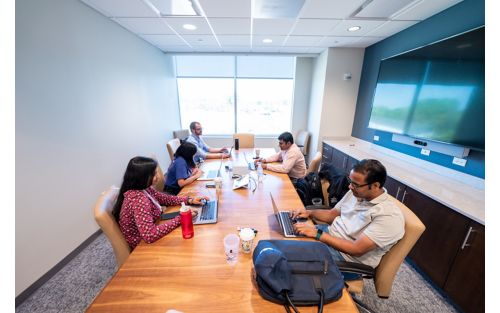 Participants in biohackathon sitting at large table