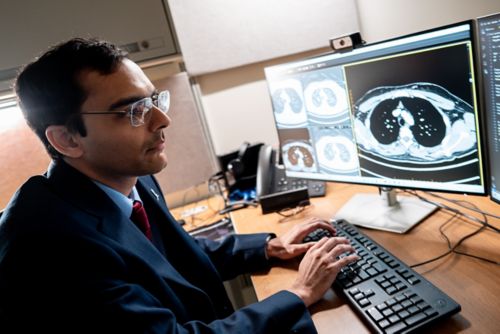 Mukherjee looking at scans on a computer screen