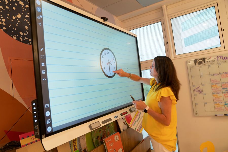 Teacher writing on media board in classroom