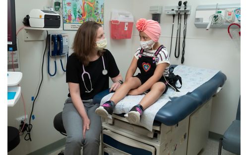 Female child patient with doctor in hospital room