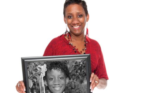 Image of woman in red shirt holding photo of herself