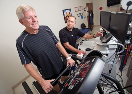 photo of man on treadmill being monitored by physical therapist