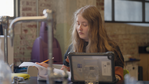 young female working in science class