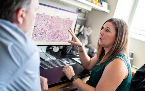 image of woman talking to man in front of computer