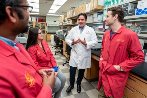 A group of people in a lab. All are wearing lab coats