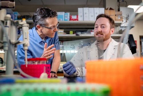 Mark Hatley explaining something to a co-worker in the lab