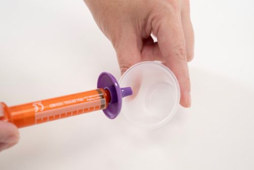 A DoseMate attachment can be used with the ENFit syringe to draw up medication from a dispensing cup.