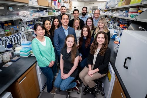 group of people posing for a photo in a lab