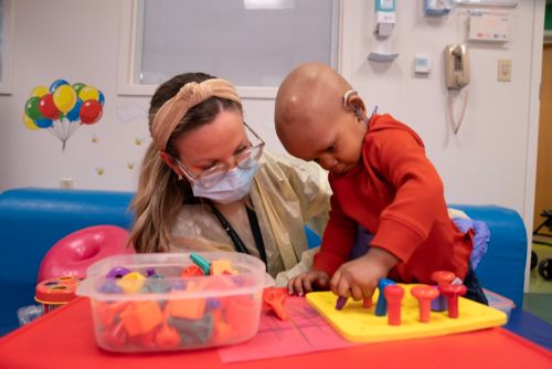 Child playing with blocks with an occupational therapist