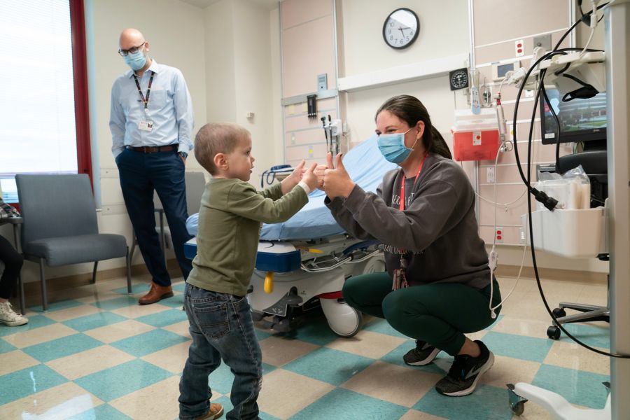 Small male child and nurse give each other thumbs up