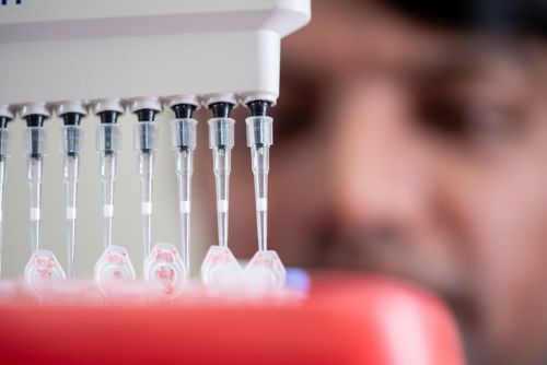 image of lab equipement w/person's face blurry in background