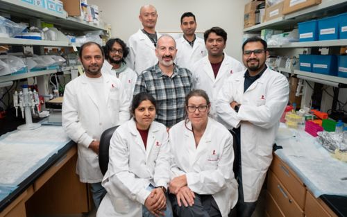 image of group of people in white coats in lab setting