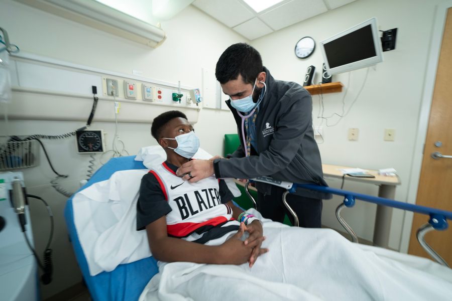 Doctor checking heart rate of patient in hospital bed
