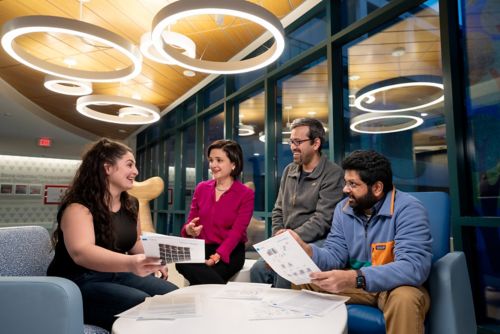 Four people sitting around a table looking at papers