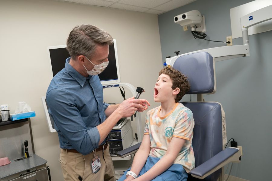 Doctor checks mouth of male child patient