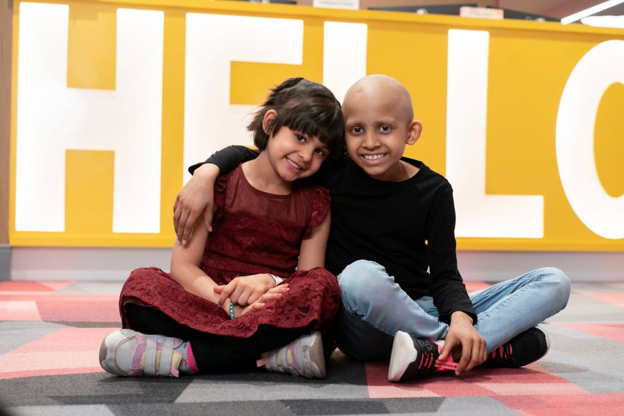 Two children smiling while sitting down