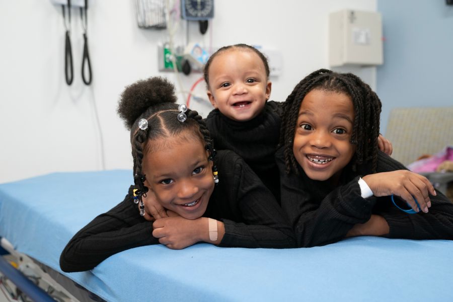 Three small children smiling in clinic setting