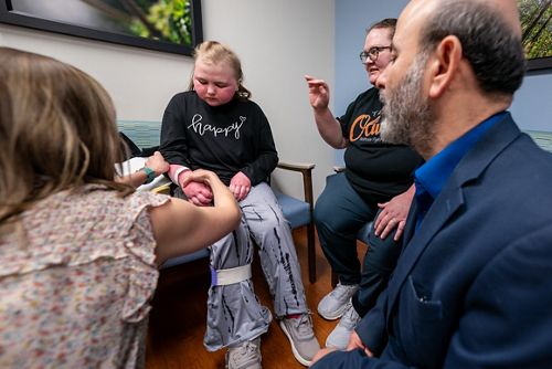 girl in exam room surrounded by adults