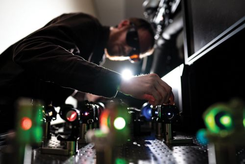 Man operating a scientific machine with eyewear on