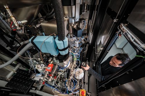 Man in gray hoodie touching a machine